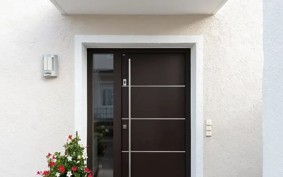 Moderne Haustür in Dunkelbraun mit Edelstahl-Applikationen und Seitenteil