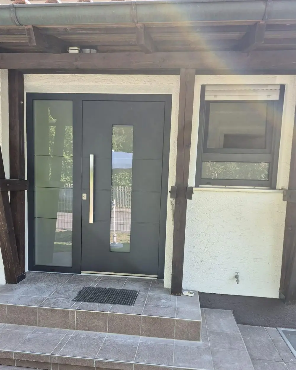 Neue Haustür in Anthrazit mit Glas-Seitenteil in Baldham, montiert von Fenstermacher24