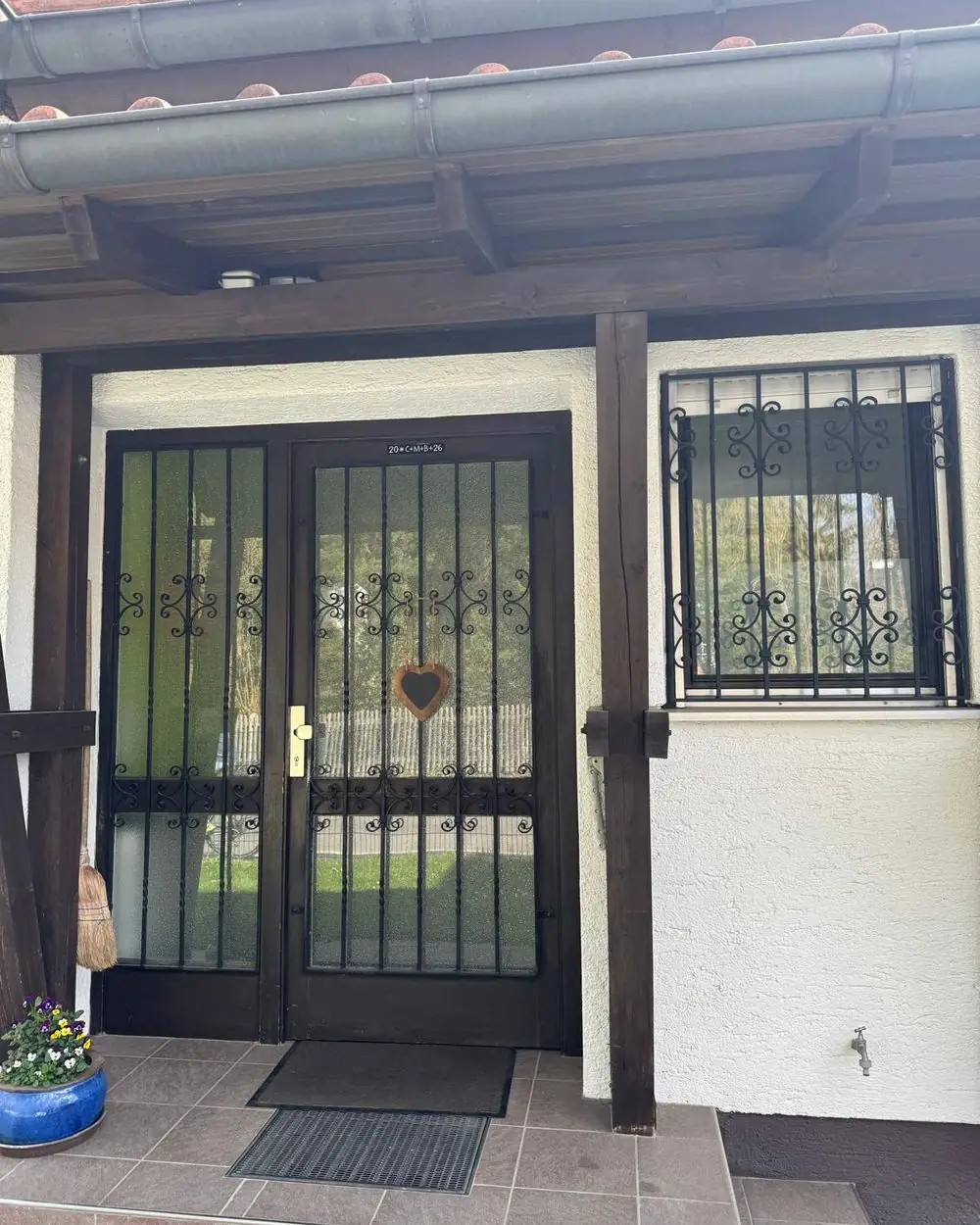 Alte zweiflügelige Haustür mit Ziergitter an einem Haus in Baldham vor dem Austausch